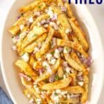 A platter of French fries topped with feta and onion with text overlay that says "Greek Fries".