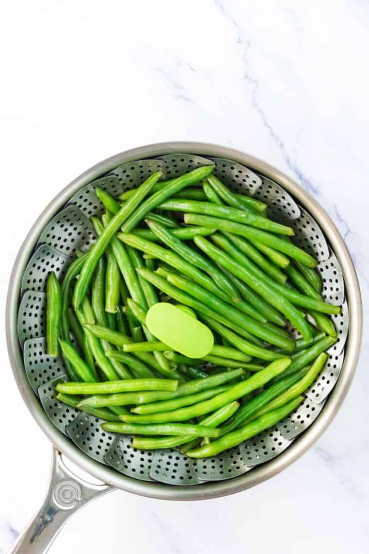 Green beans in a steamer basket.