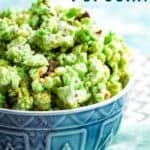 Green-colored popcorn with mini chocolate chips in a blue bowl with text overlay that says "Mint Green Popcorn".