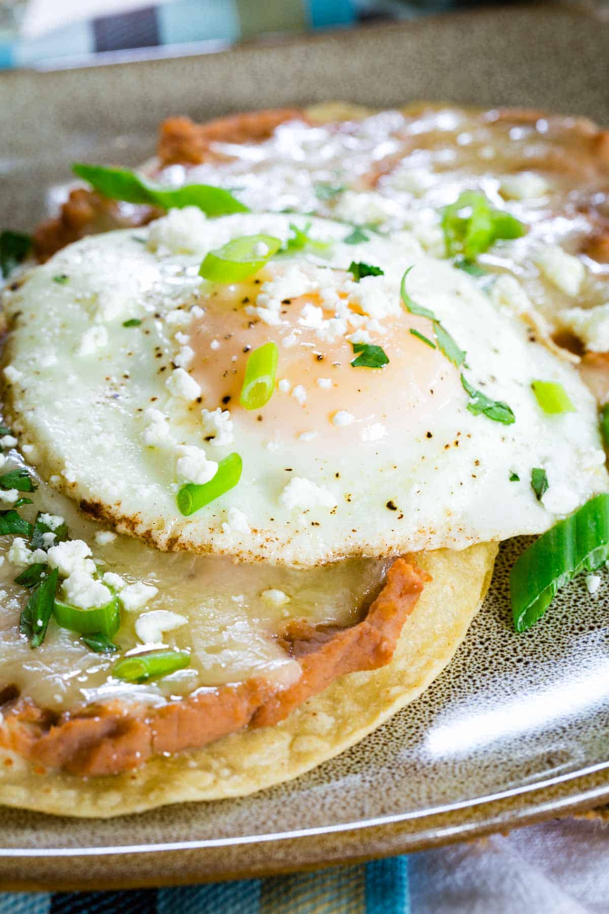 Breakfast tostadas topped with fried eggs and cilantro.