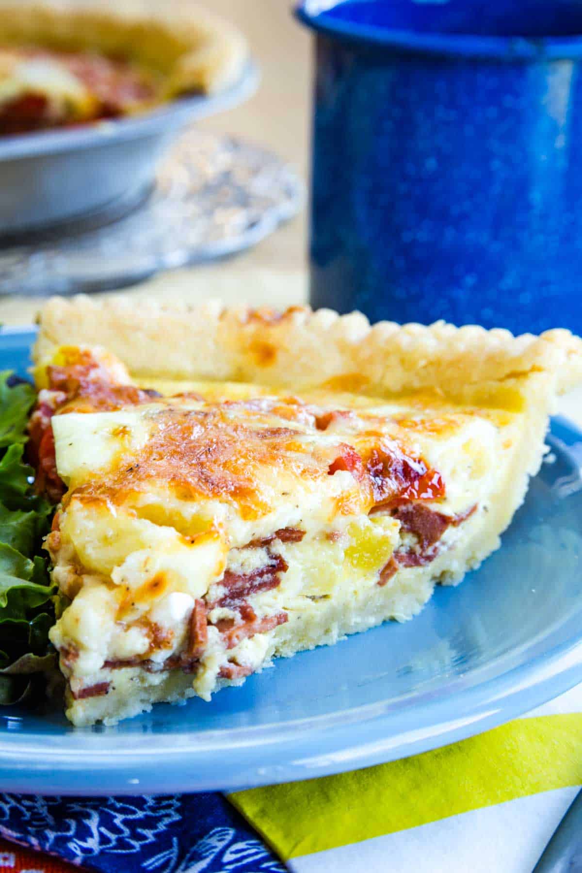 A slice of gluten free bacon cheddar quiche.