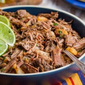 Crockpot barbacoa is served in a bowl with lime.