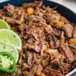 Crockpot barbacoa is served in a bowl with lime.