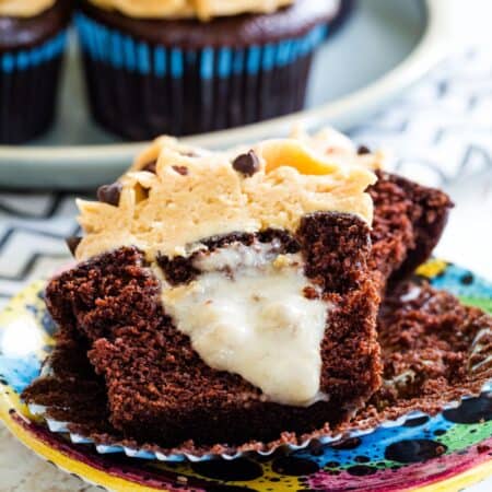 A peanut butter frosted chocolate cupcake cut in half to show the creamy banana filling.