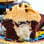 A chocolate cupcake with peanut butter frosting cut in half to show the banana filling with text overlay that says "Funky Monkey Chocolate Cupcakes".