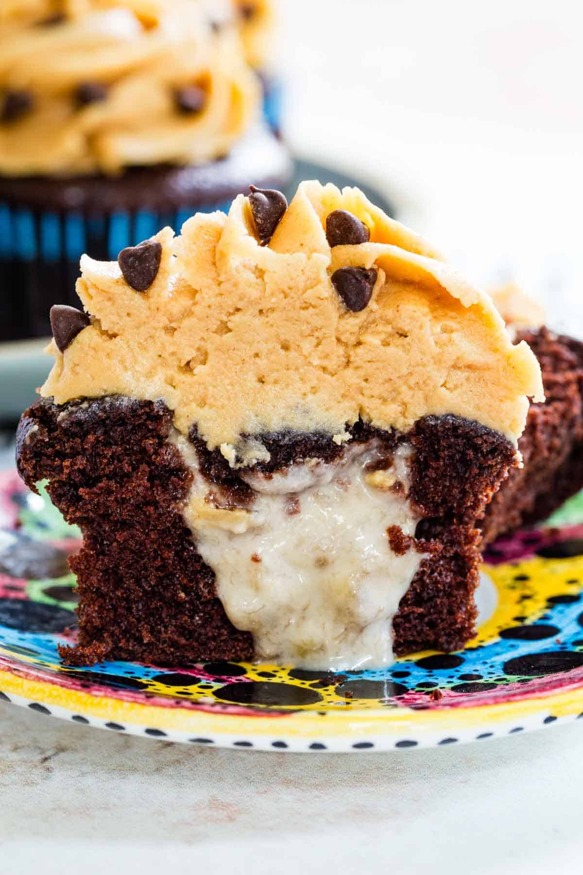 A half of a peanut butter frosted chocolate cupcake with the banana filling oozing out.