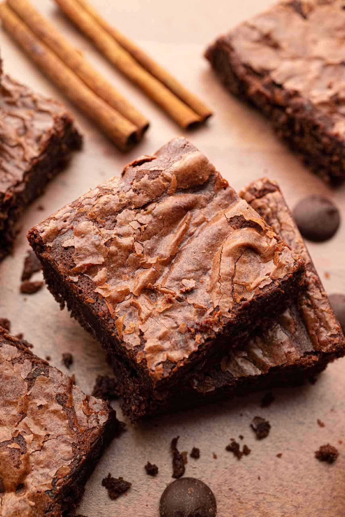 A few Mexican brownies next to two cinnamon sticks.
