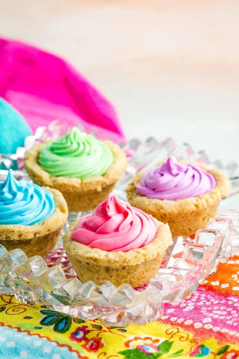 Four sugar cookie cups with colorful frosting.