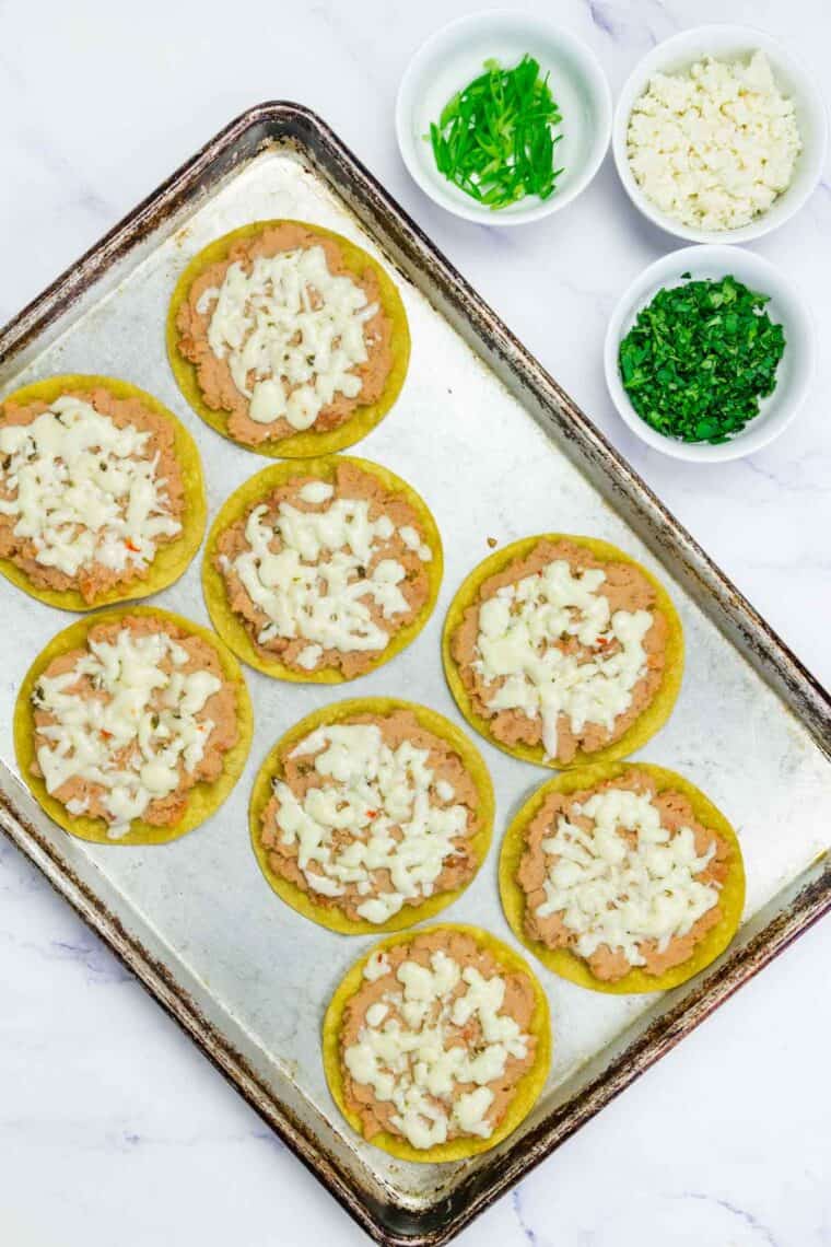Corn tortillas are layered with melted cheese for breakfast tostadas.