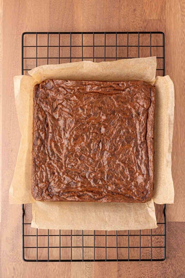 Mexican brownies cool on parchment paper on a rack.
