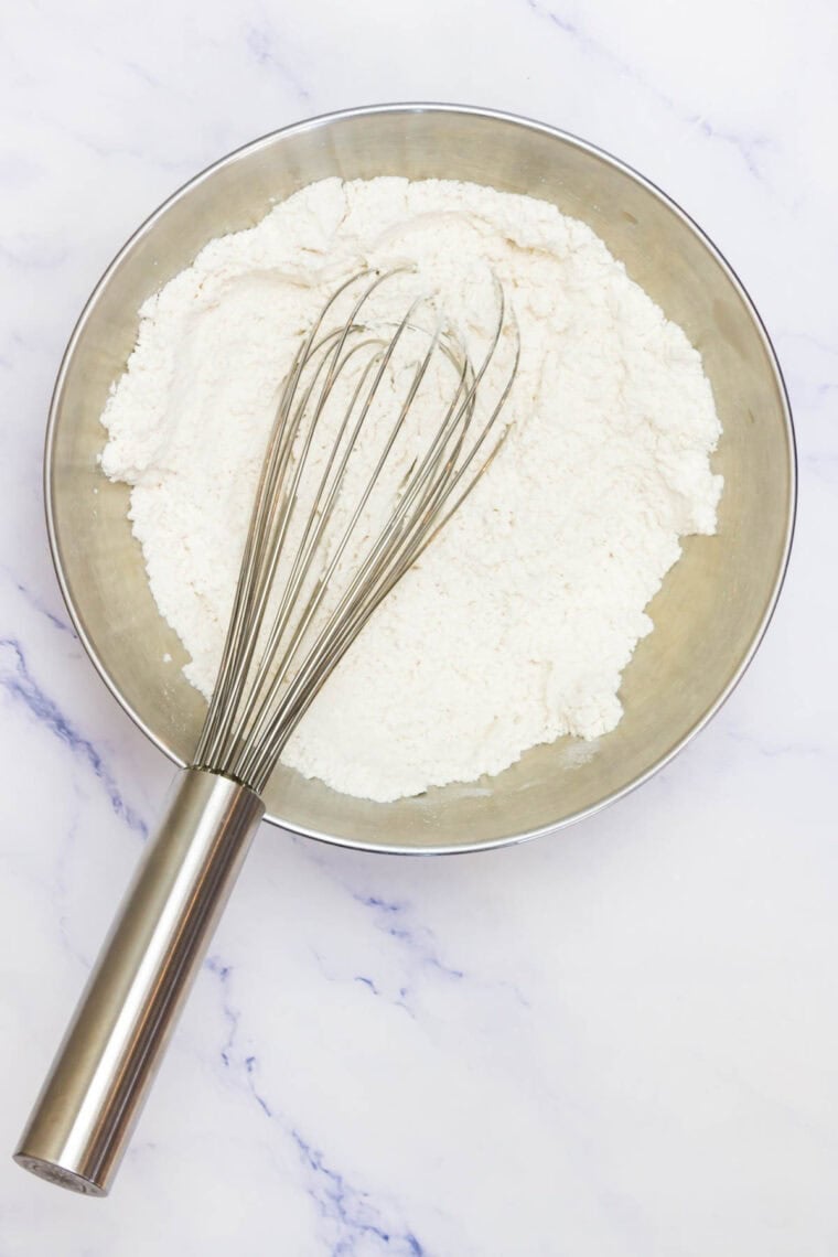 The dry mix for sugar cookie cups is whisked in a bowl.