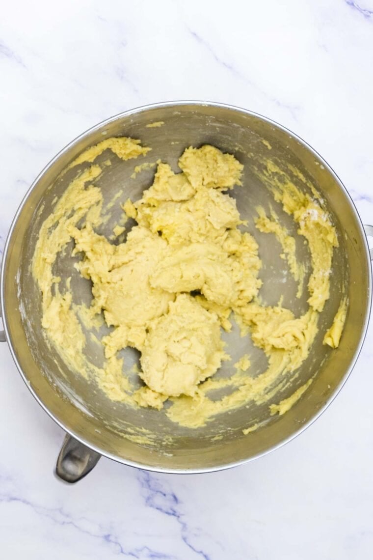 The wet and dry mixes are combined in a bowl for sugar cookie cups.