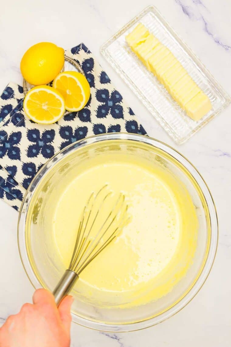 Lemon juice is whisked into a bowl of lemon curd.