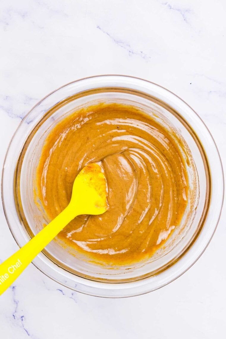 A glass bowl of melted peanut butter and honey.