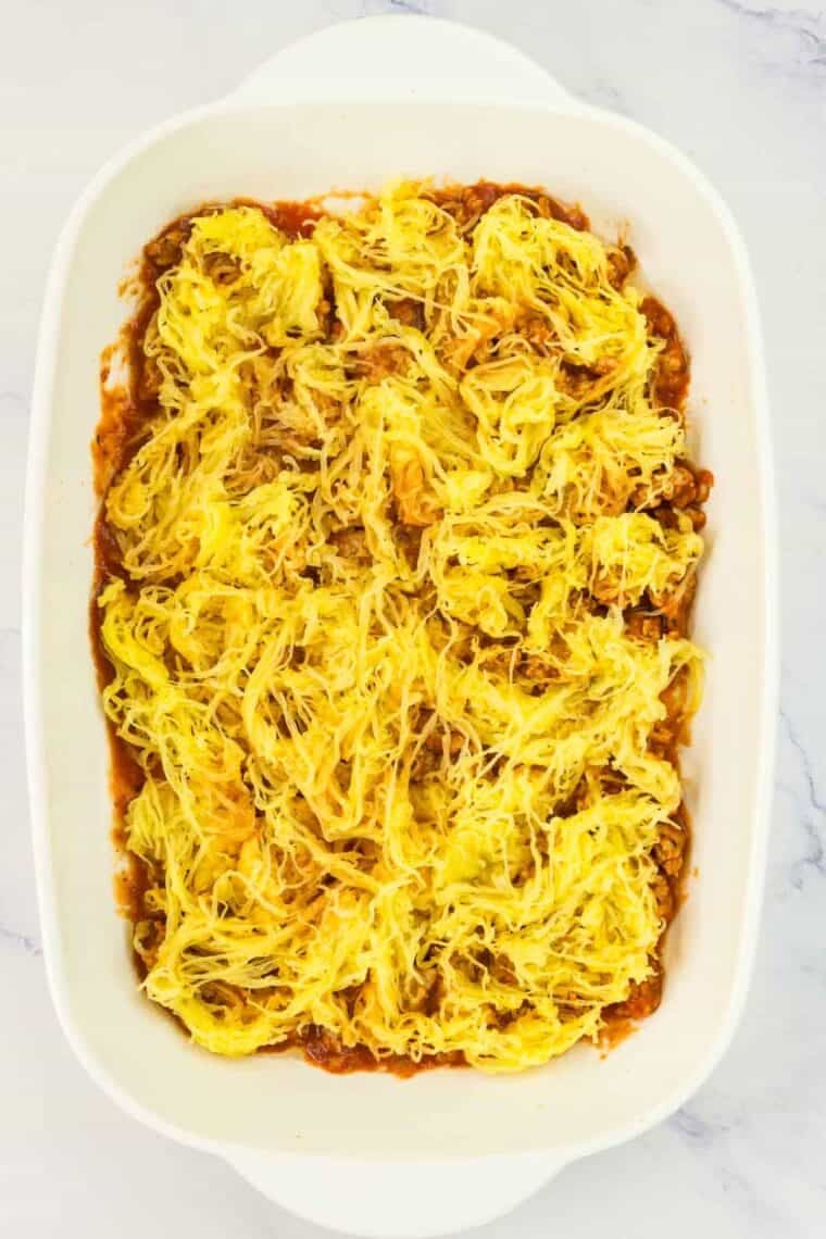 Spaghetti squash is spread over turkey sausage tomato sauce.