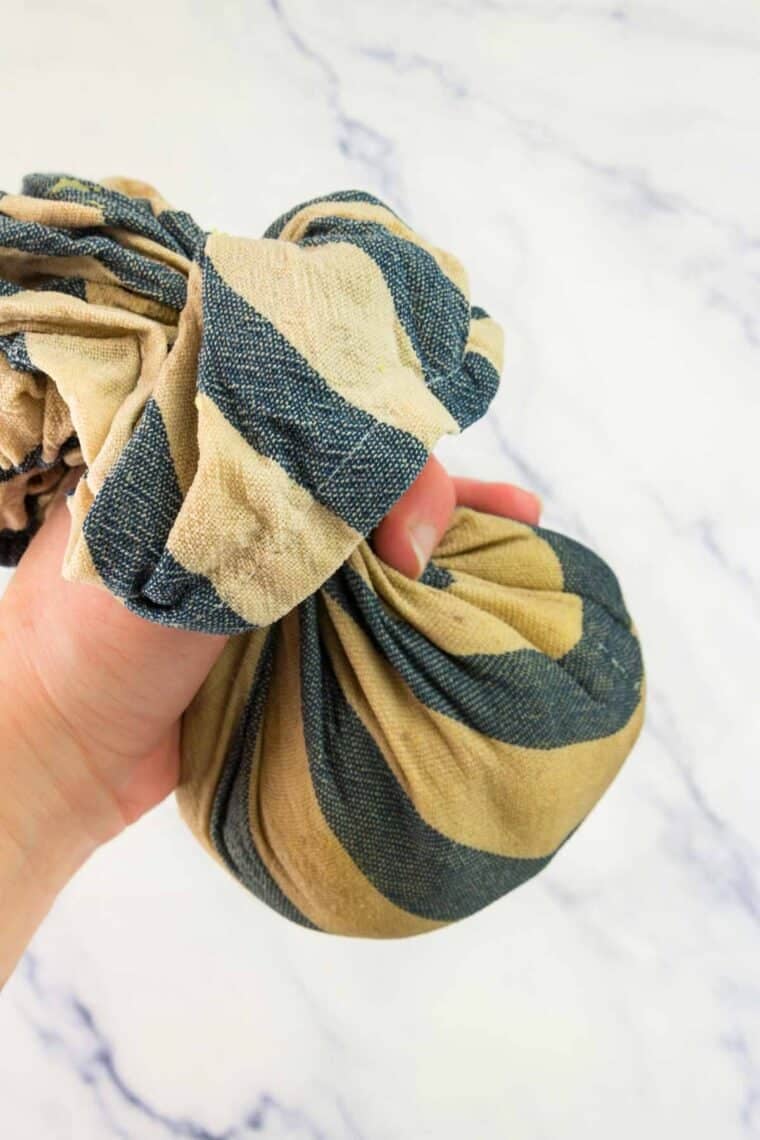 Water is squeezed out of a towel containing baked spaghetti squash.