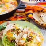 Two egg tacos on a plate with text overlay that says "Breakfast Tacos".