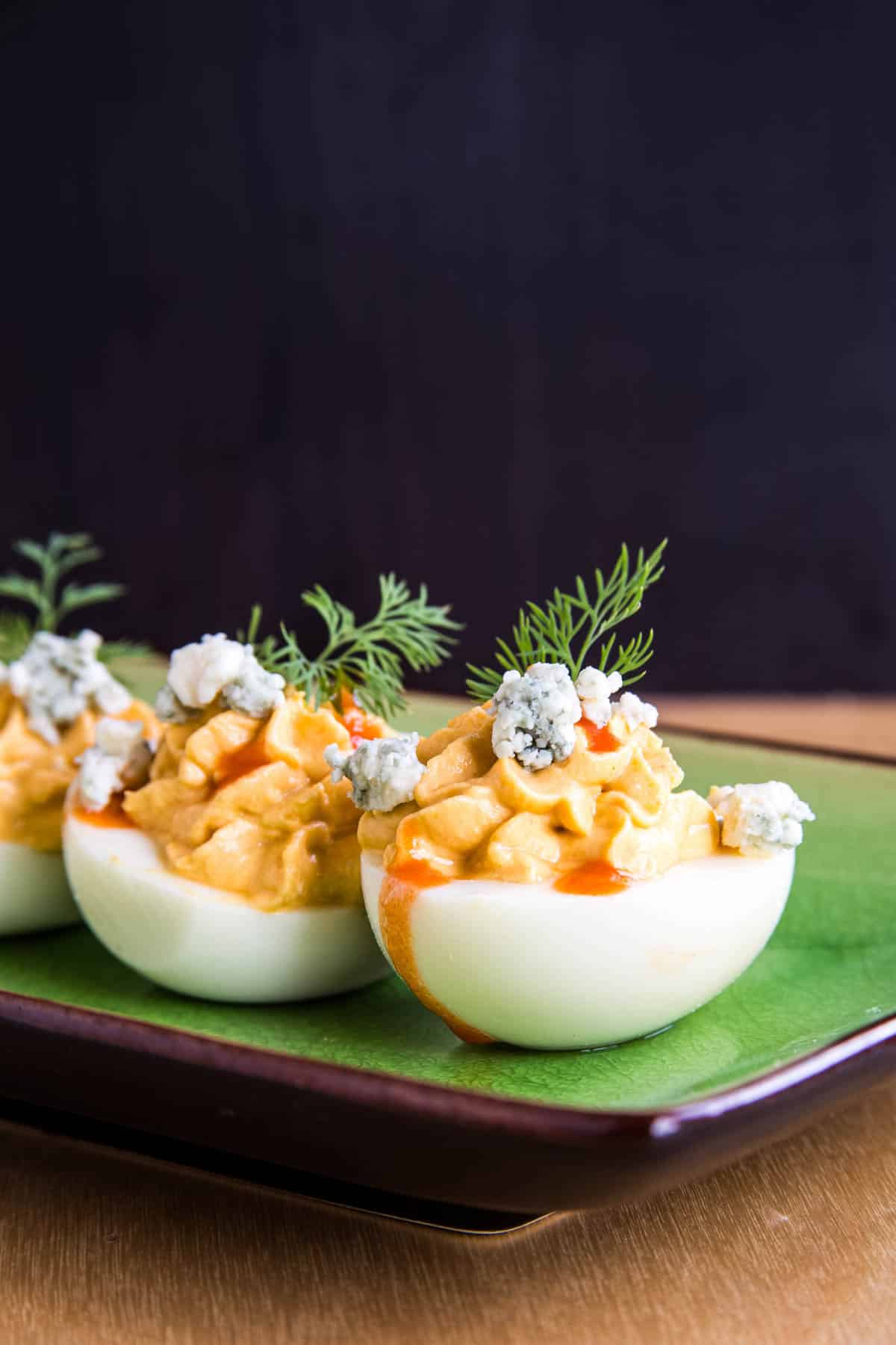Two of the buffalo deviled eggs lined up on a plate.