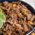 A dish of shredded beef with pineapple tidbits with text overlay that says "Crockpot Barbacoa".