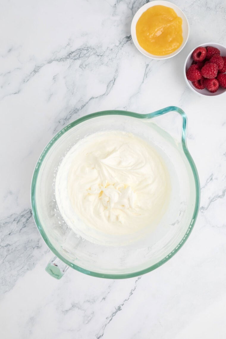 Whipped cream in a glass measuring cup.