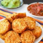 Cauliflower tots, salsa, and guacamole on a table.
