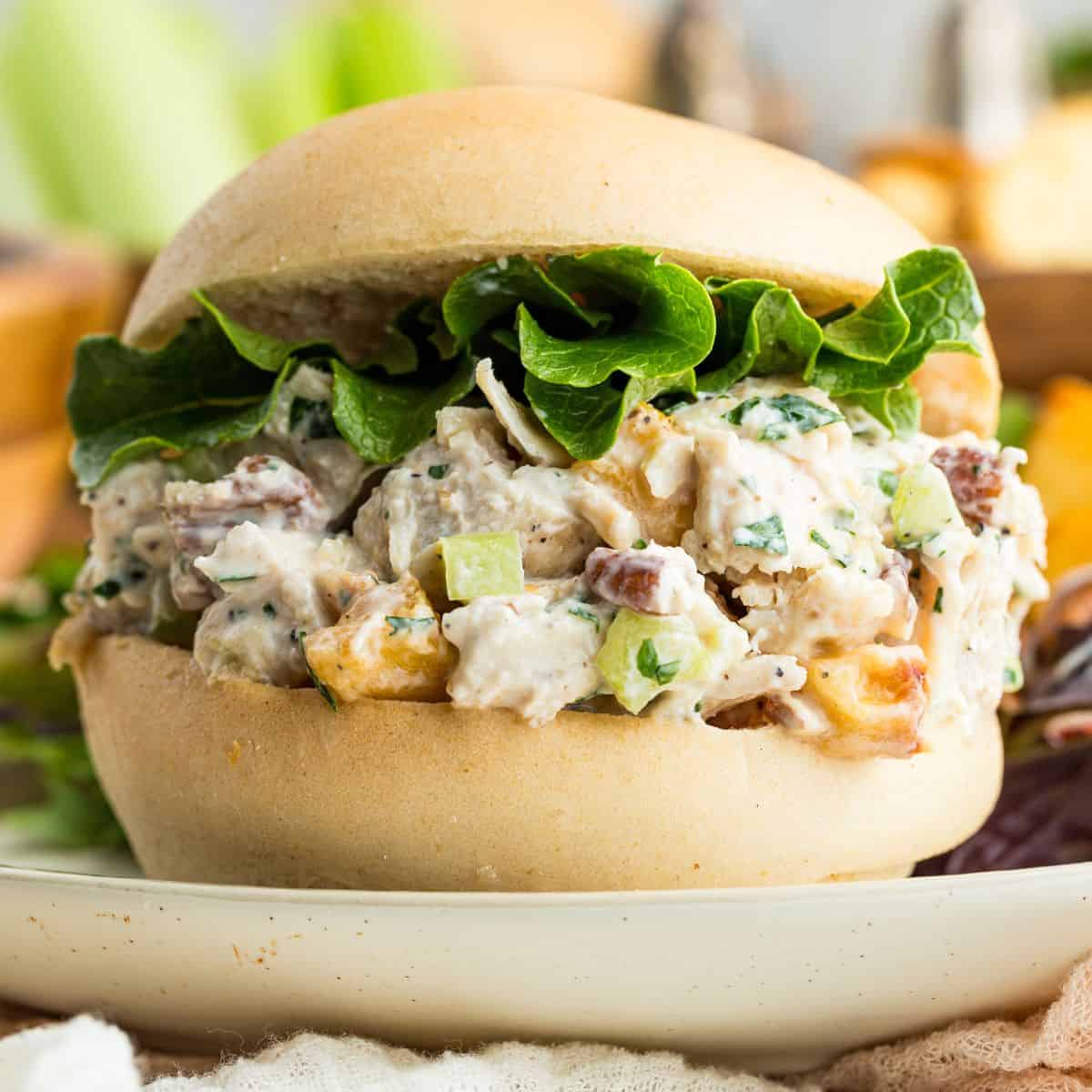 Pecan chicken salad served on a roll with lettuce.