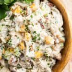 Cilantro garnishes a bowl of pecan chicken salad with peaches.