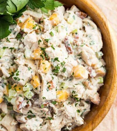 Cilantro garnishes a bowl of pecan chicken salad with peaches.