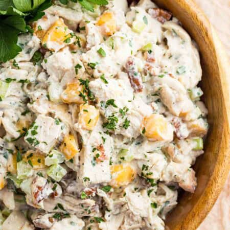 Cilantro garnishes a bowl of pecan chicken salad with peaches.