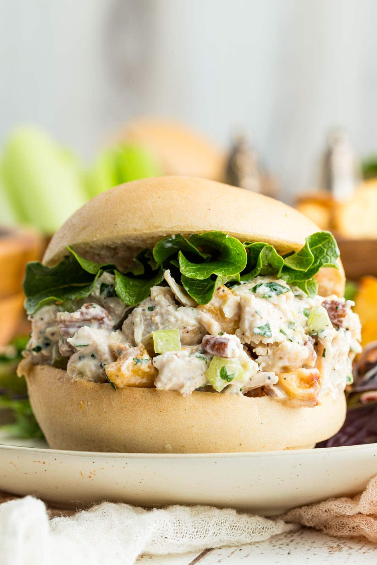 Pecan chicken salad served on a roll with lettuce.