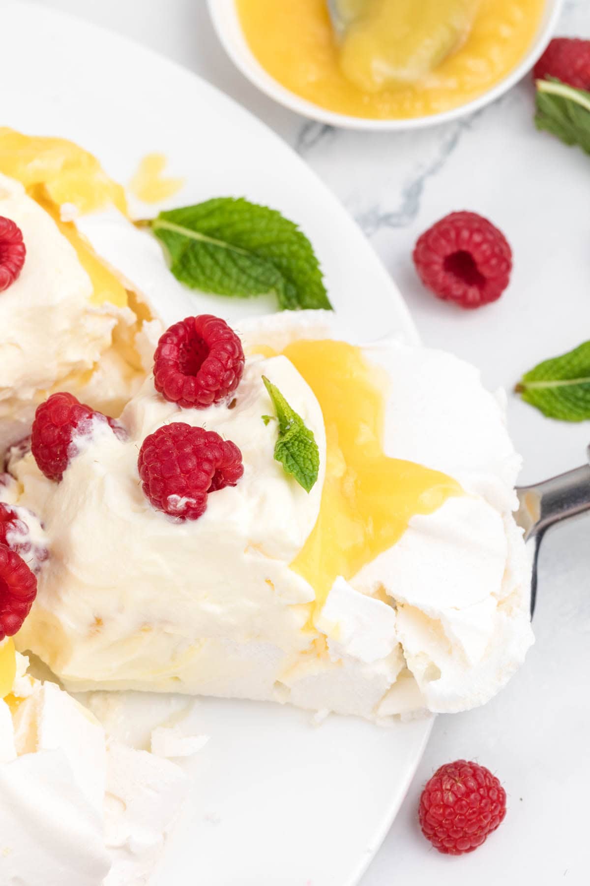Fresh mint garnishes a slice of pavlova.