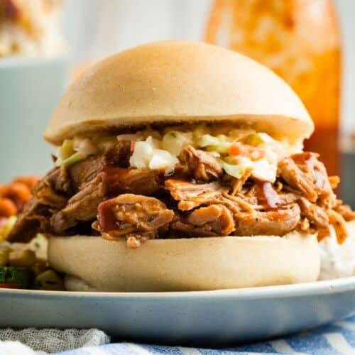 Slow cooker pulled pork is served as a sandwich on a bun.