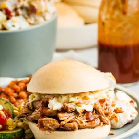 Slow cooker pulled pork is served as a sandwich on a bun.
