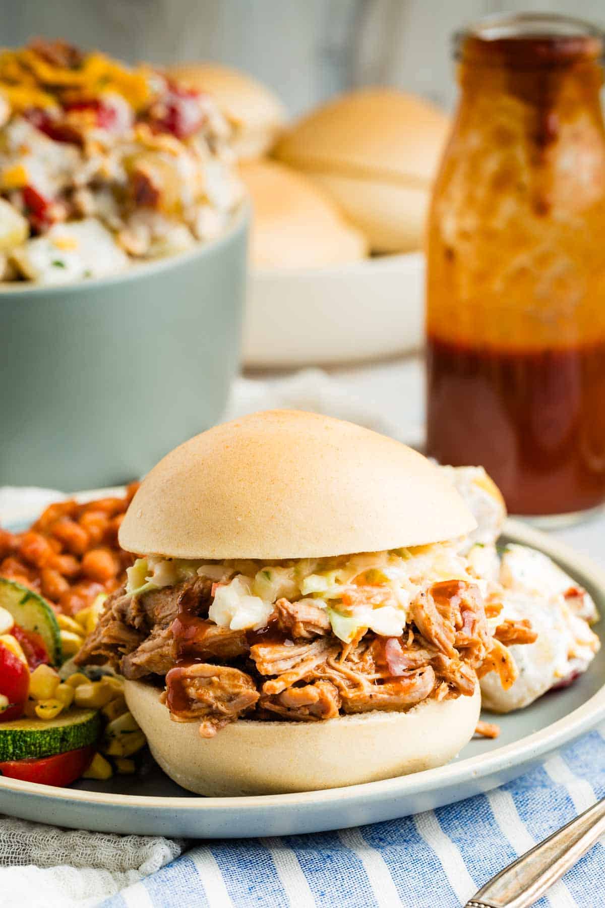 Slow cooker pulled pork is served as a sandwich on a bun.