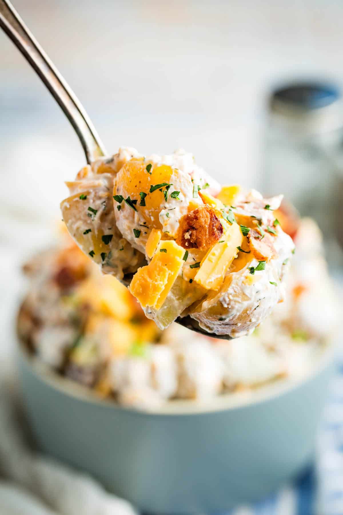 A spoonful of ranch potato salad is lifted up.