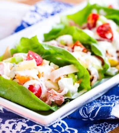 A plate of ham and turkey lettuce wraps.