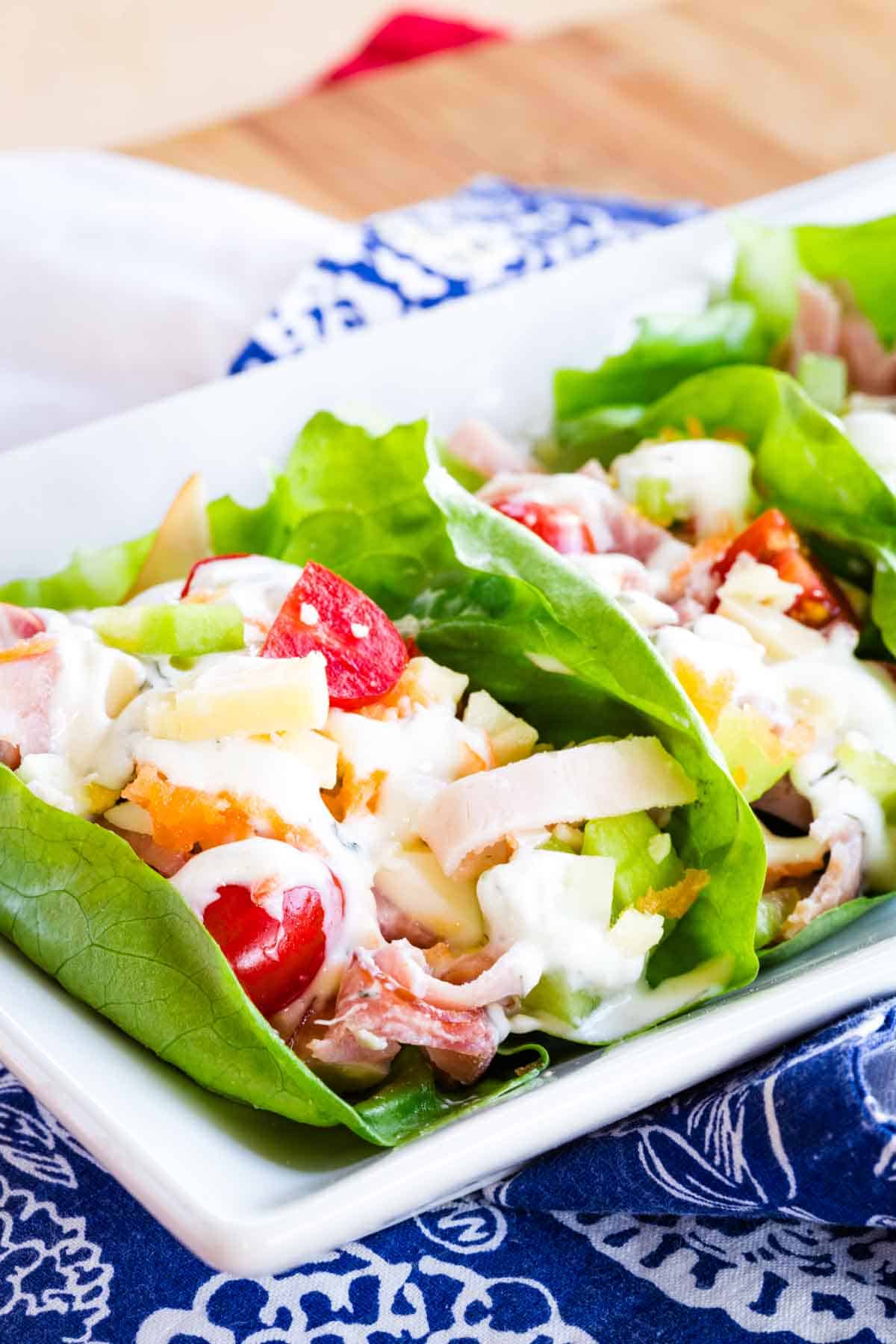 Easy ham and turkey lettuce wraps are packed with savory deli ham and turkey, fresh veggies, and Ranch dressing. Great for lunch! Ham and turkey lettuce wraps stuffed with tomatoes.
