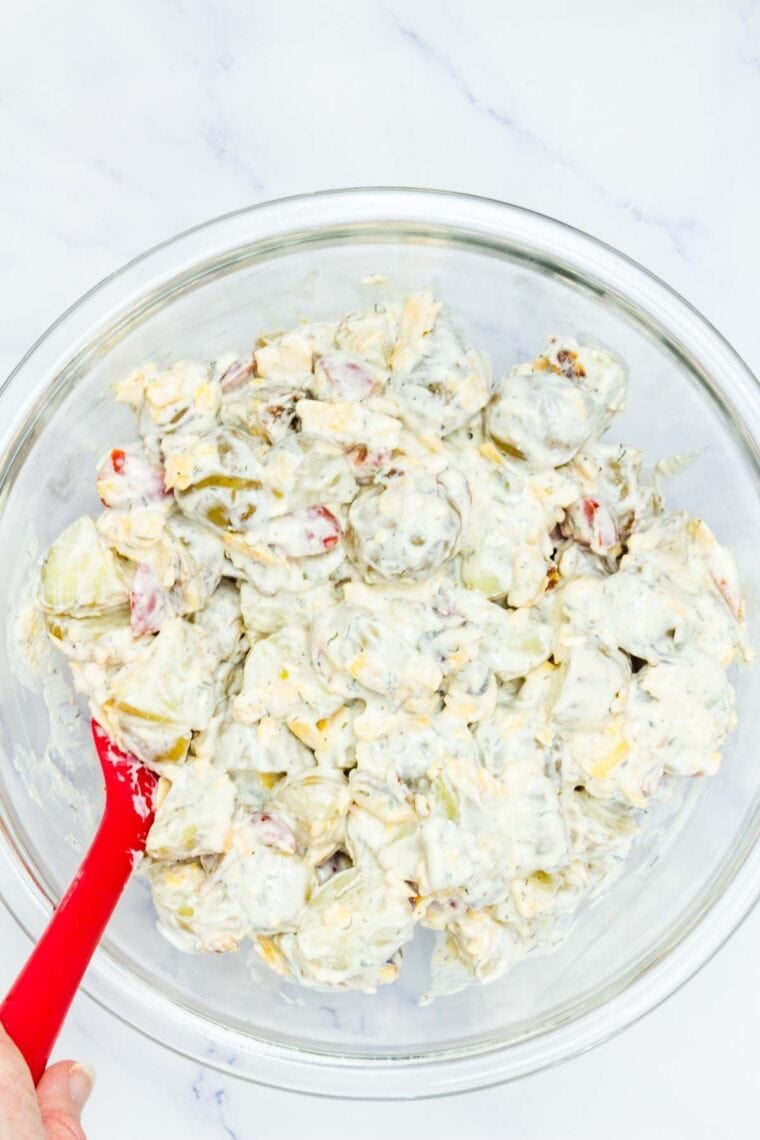 Dressing is stirred into ranch potato salad.