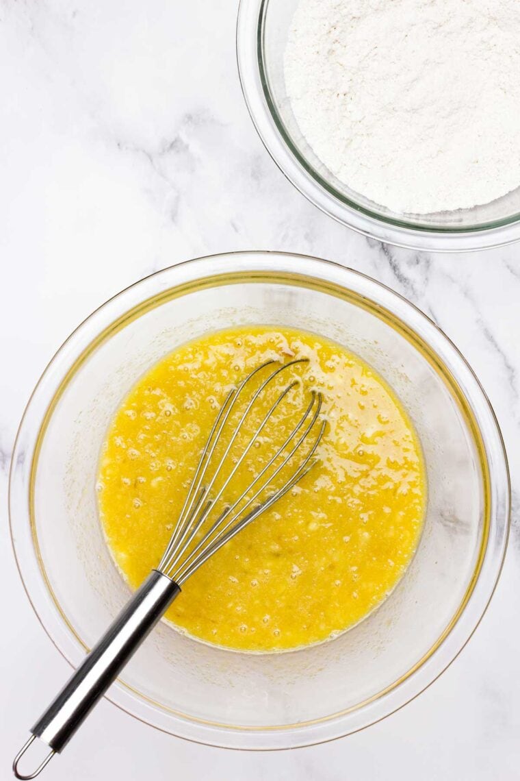 Eggs are whisked with bananas in a bowl.