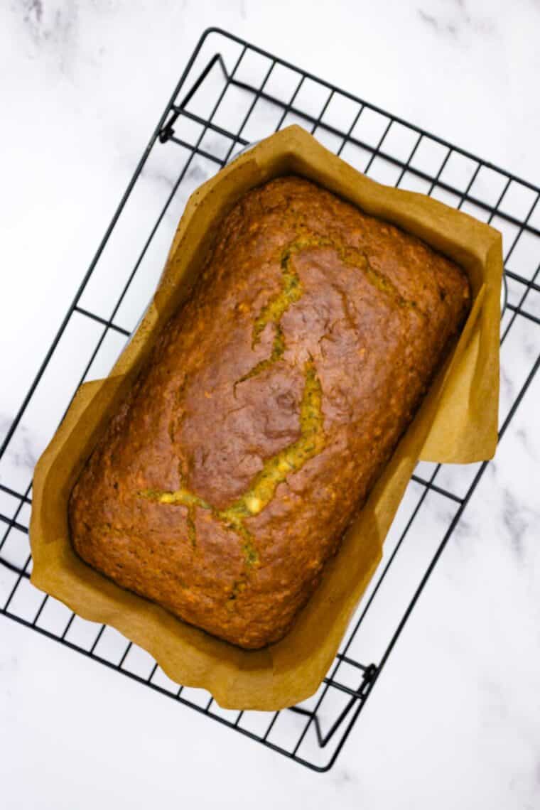 A loaf of gluten-free banana bread cools in a pan.