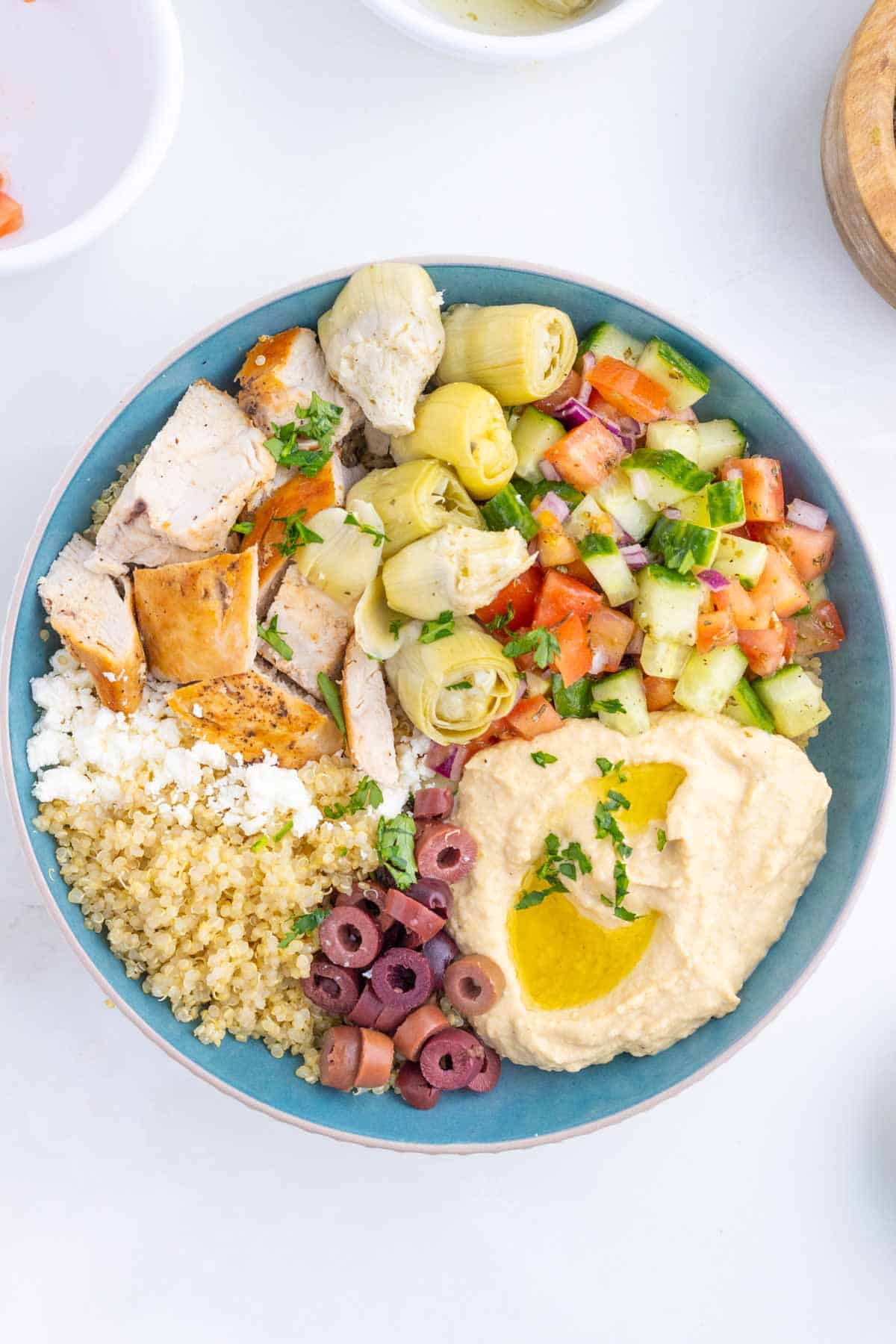 Overhead image of a Greek chicken bowl with hummus.