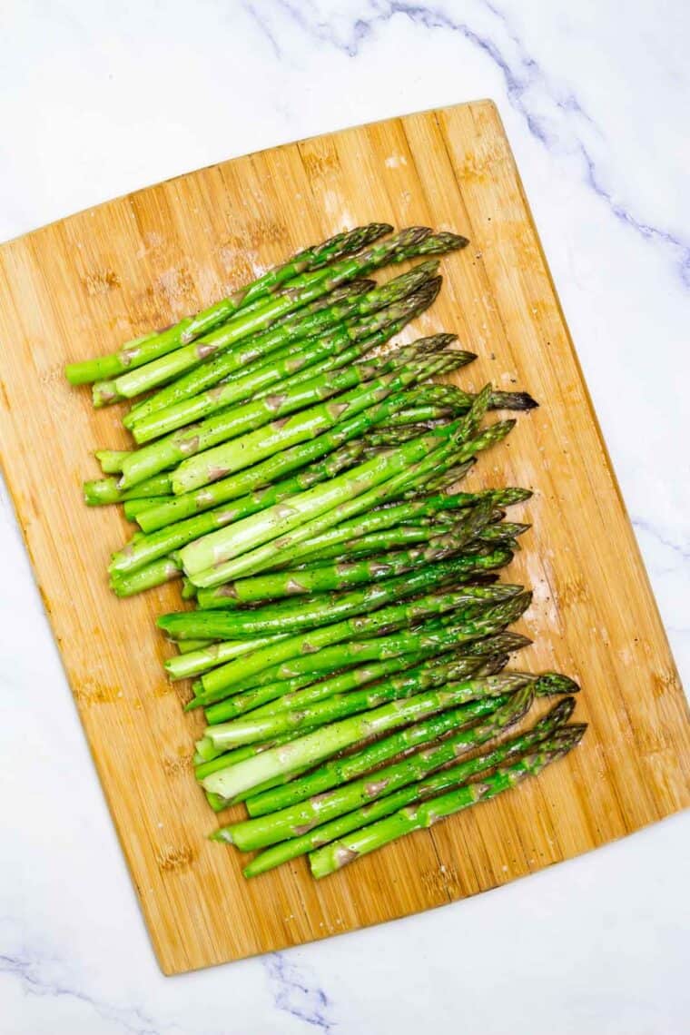 Asparagus on a wooden cutting board.
