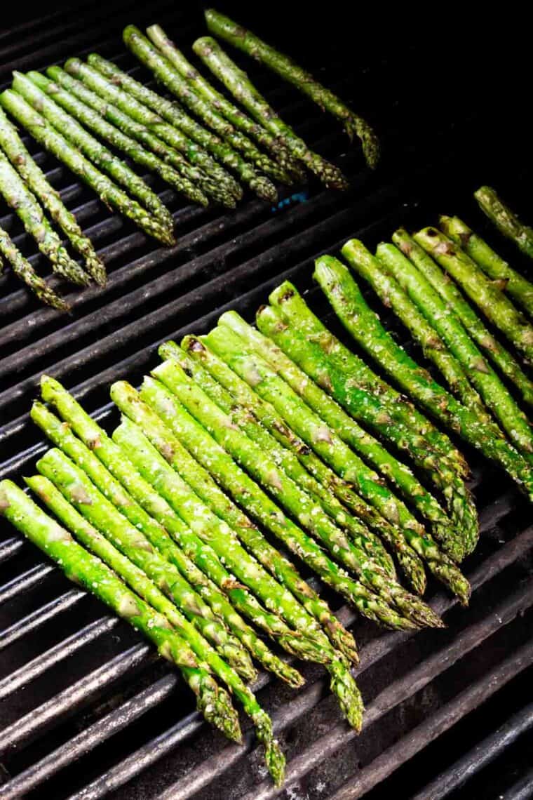 Asparagus spears cook on the grill.