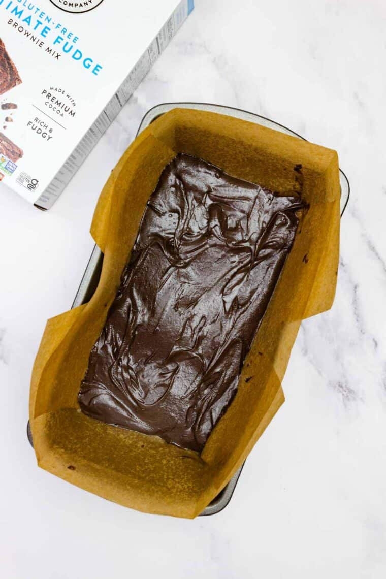 Brownie batter added to a line baking pan.