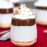 A mini cheesecake parfait with text overlay that says "No-Bake Nutella Cheesecake Cups".