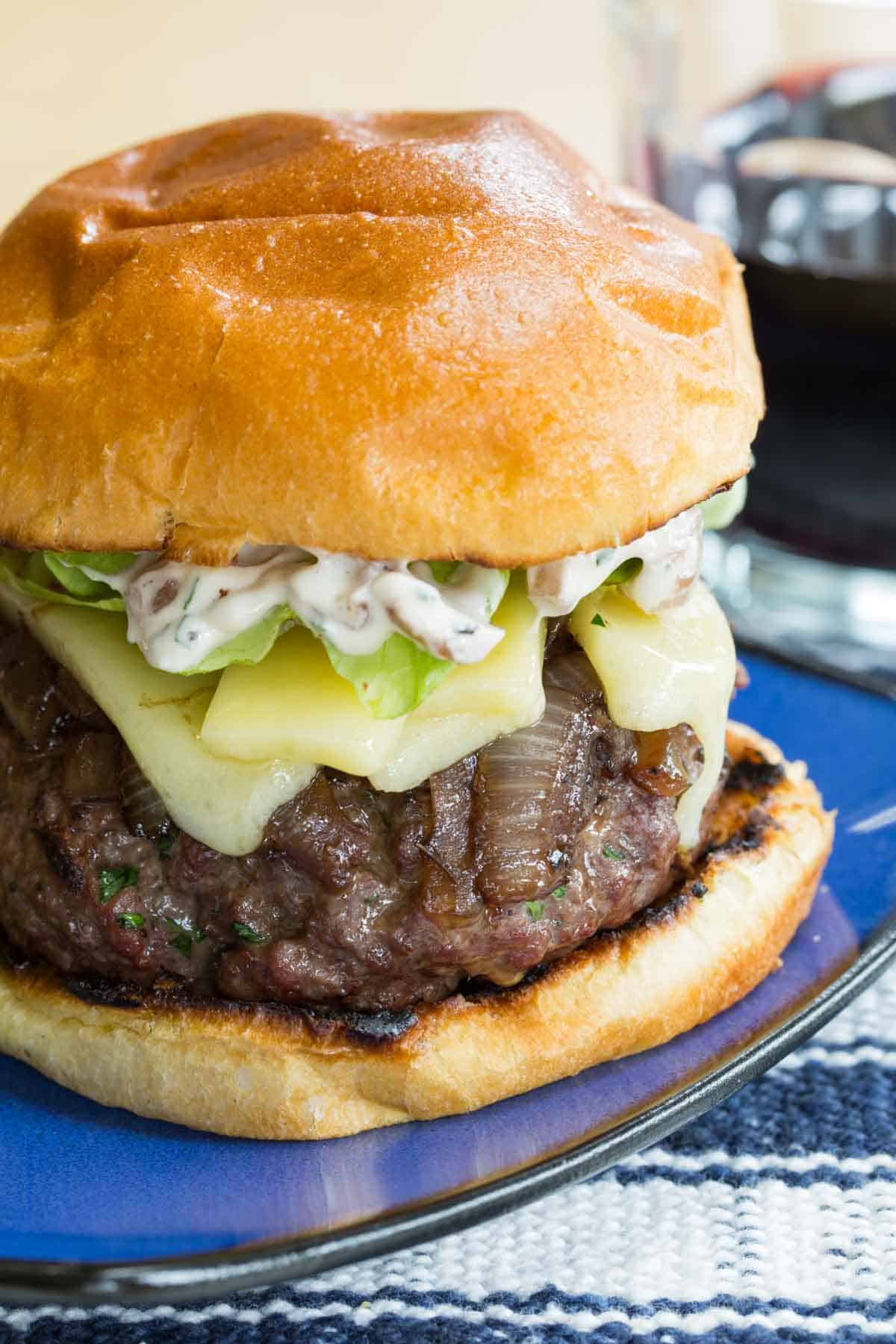 A stuffed French onion burger on a blue plate.