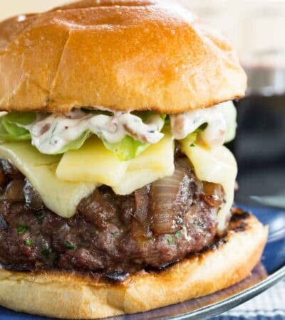 A French onion burger on a blue plate.