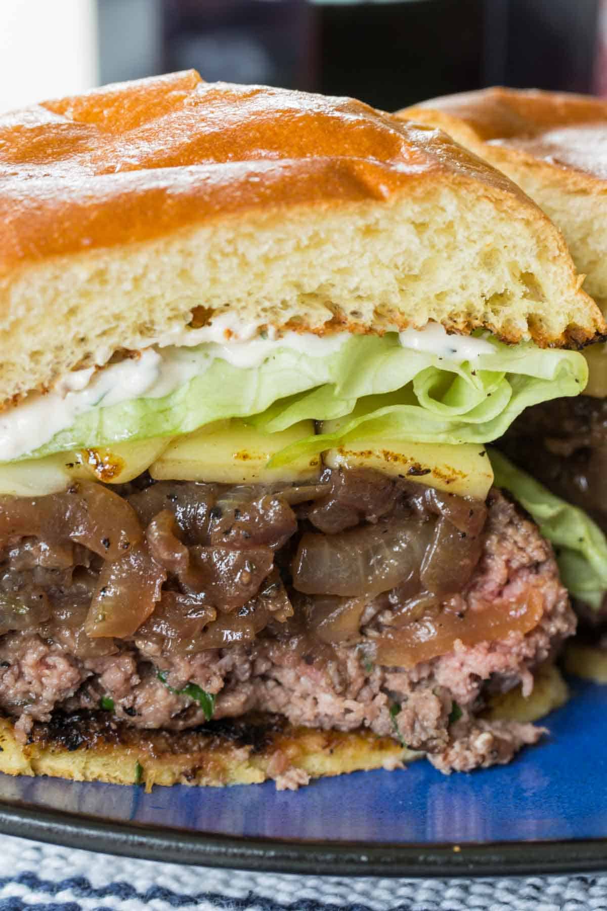 Close-up image of a French onion burger cut in half.