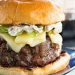 A burger topped with caramelized onions and cheese with text overlay that says "French Onion Burgers".