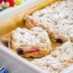 A slice of coffee cake with strawberry and blueberry filling in a baking pan with text overlay that says "Gluten Free Berry Crumb Cake".